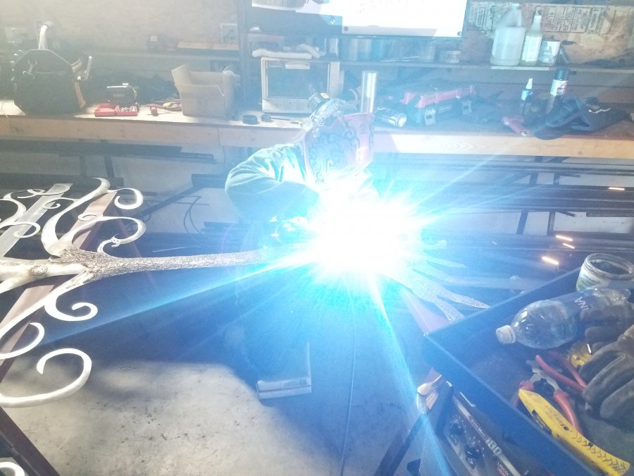 Madylynn using the mig welder and grinder to texture the tree