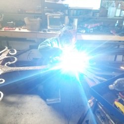 Madylynn using the mig welder and grinder to texture the tree